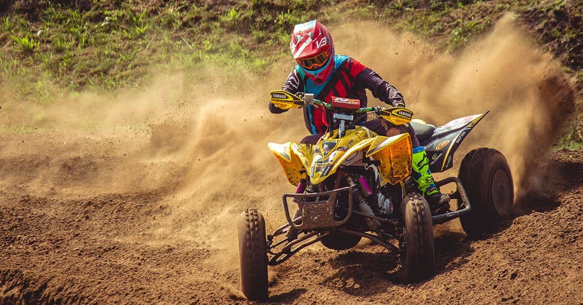 ATV kicks up dirt around a turn